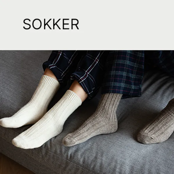 To barn med varme Tova tøfler på. Gode tøfler som sitter stødig på foten. En snill storesøster løfter opp lillesøster. Gode støvler til skolen, barnehagen, hjemme og på hytta. Foto med tekst. Leder til side med alle baby- og barnetøfler.